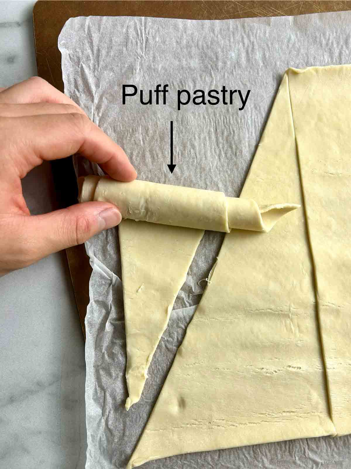 puff pastry being rolled into croissant shape.