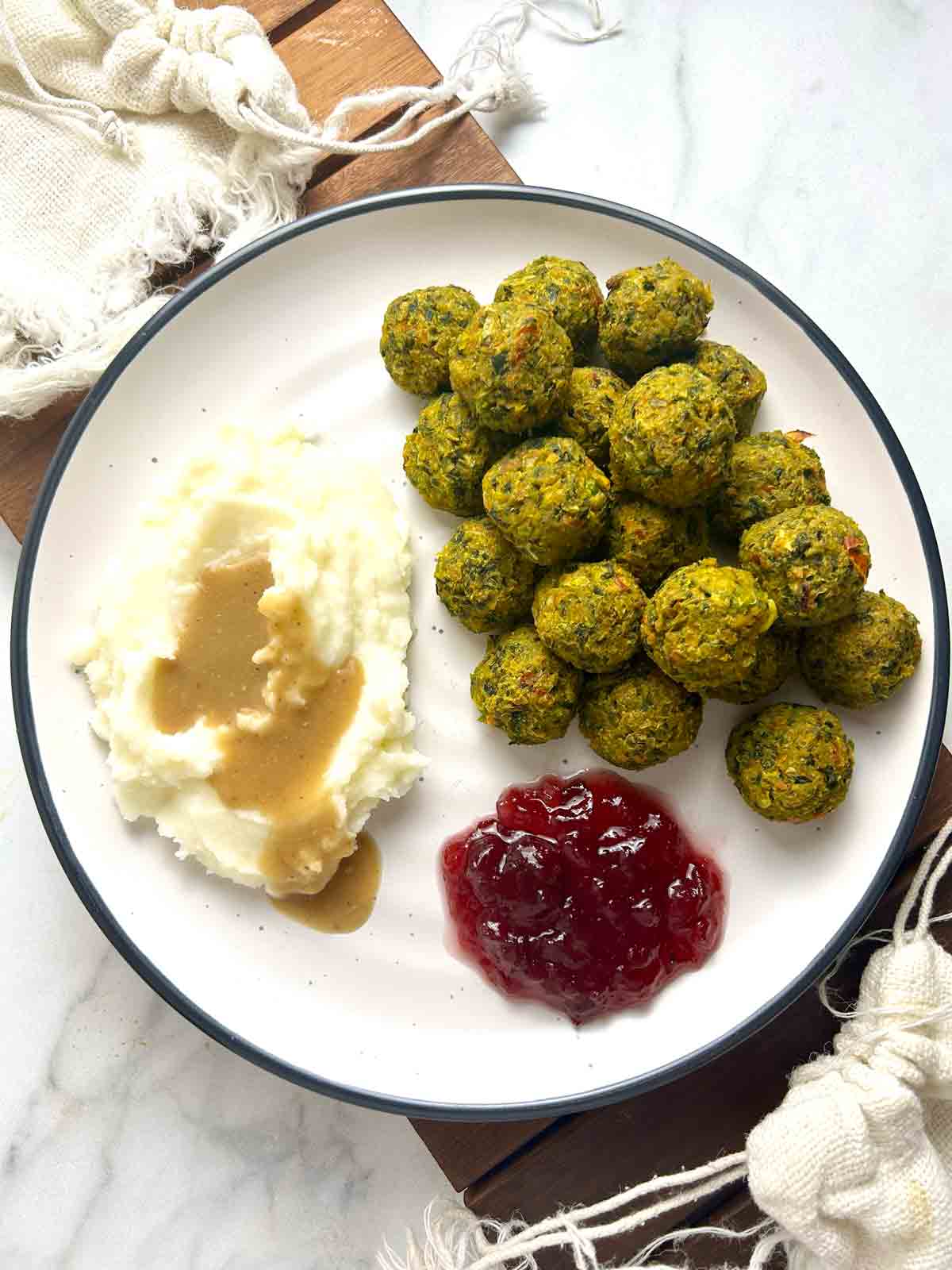 plate of Ikea veggie balls with mashed potatoes, gravy, and cranberry sauce.