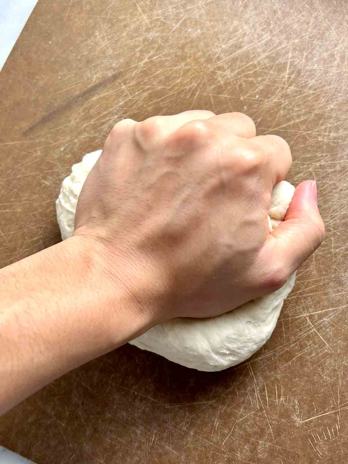 hand kneading dough ball.