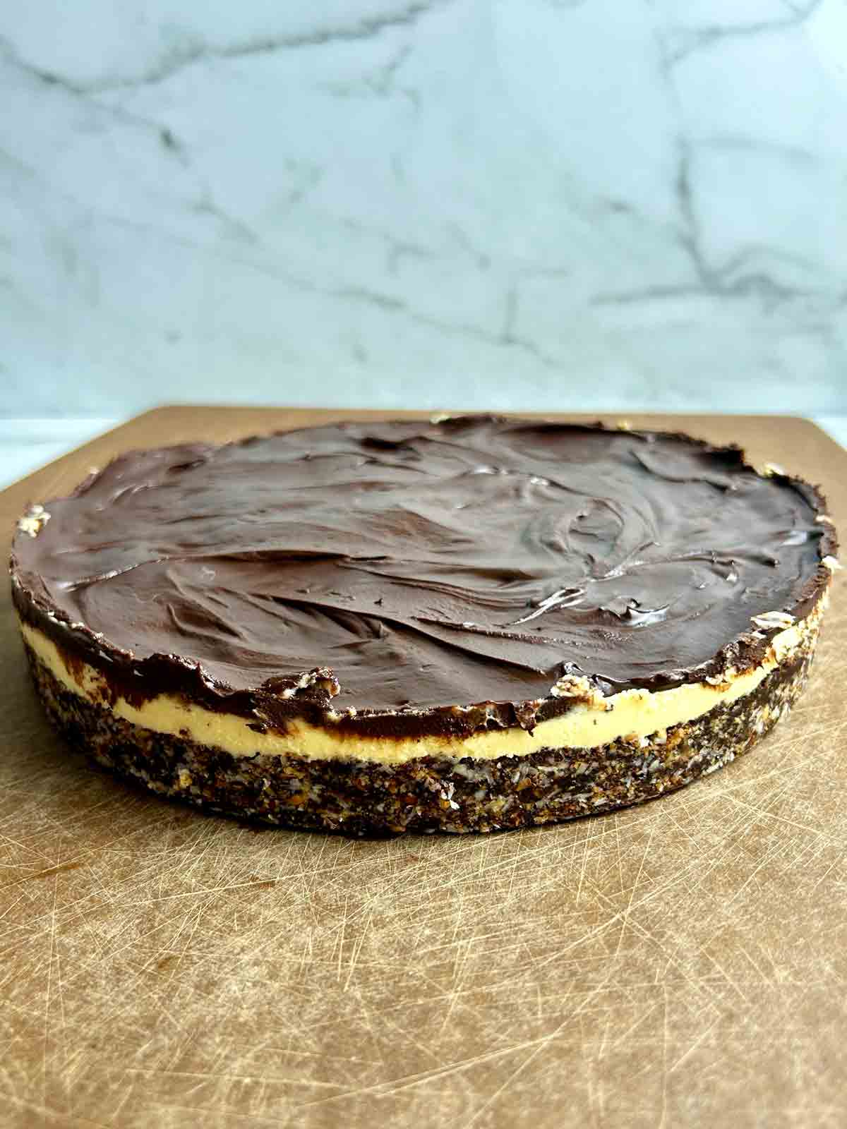 Whole Nanaimo bar slab on a cutting board, uncut.