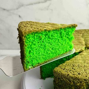 slice of pandan cake being lifted from cake.