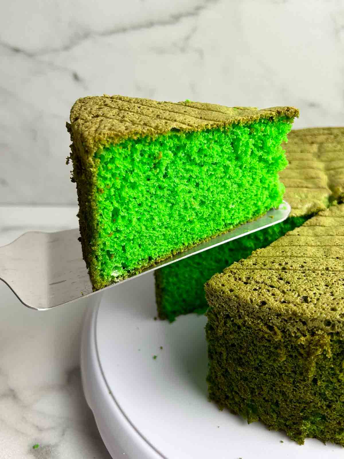 slice of pandan cake being lifted from cake.