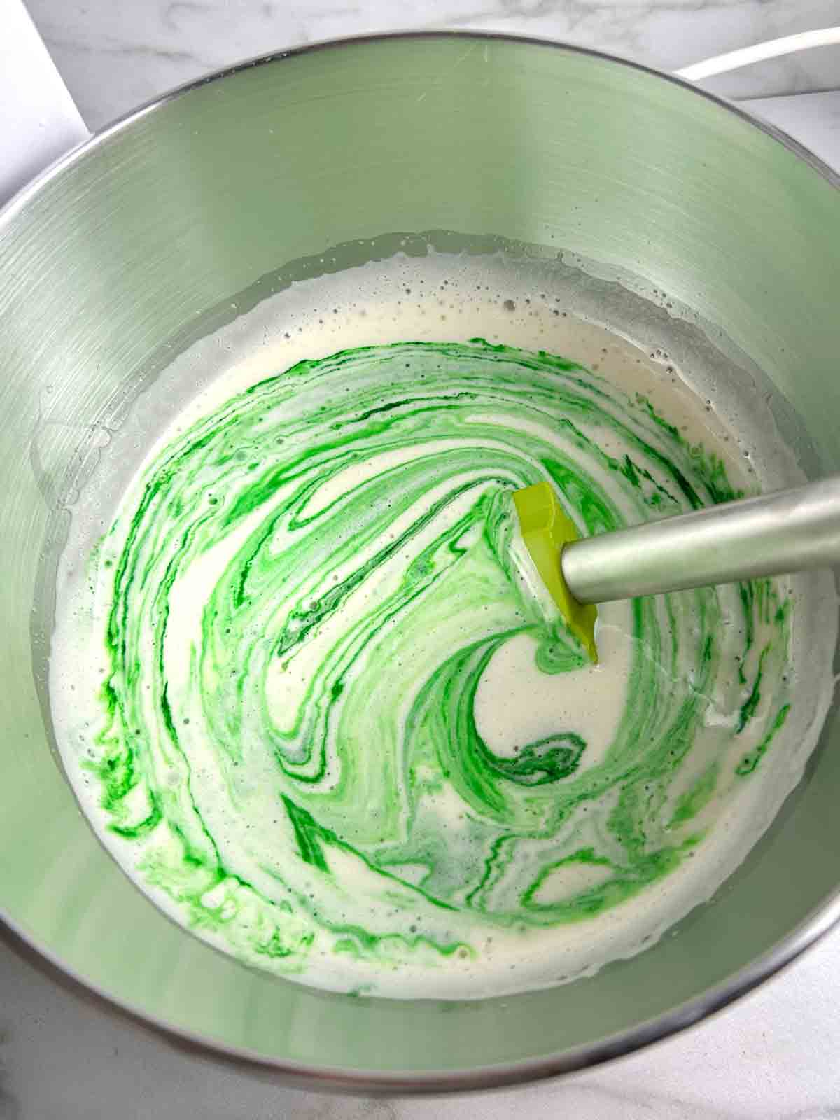 pandan extract being stirred into cake batter.