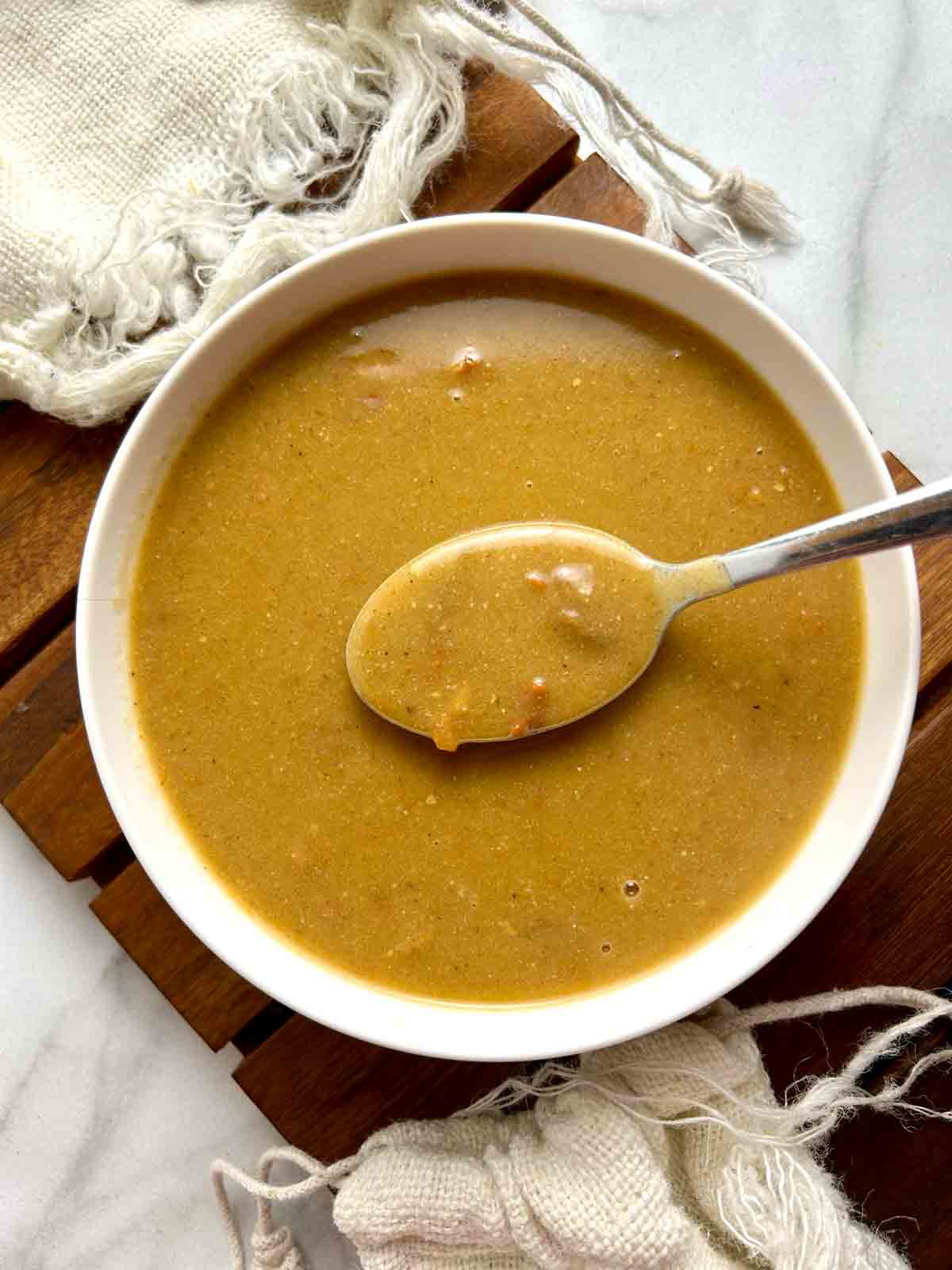 spoon lifting Popeye's cajun gravy out of bowl.