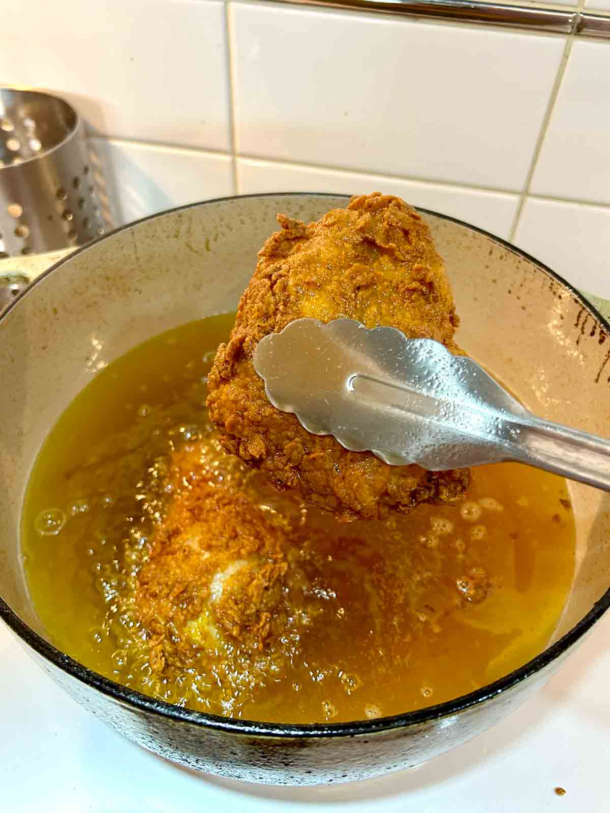 fried chicken being pulled out of oil.