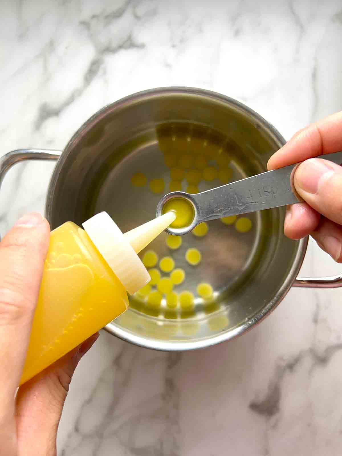 squeezing mango juice into measuring spoon.