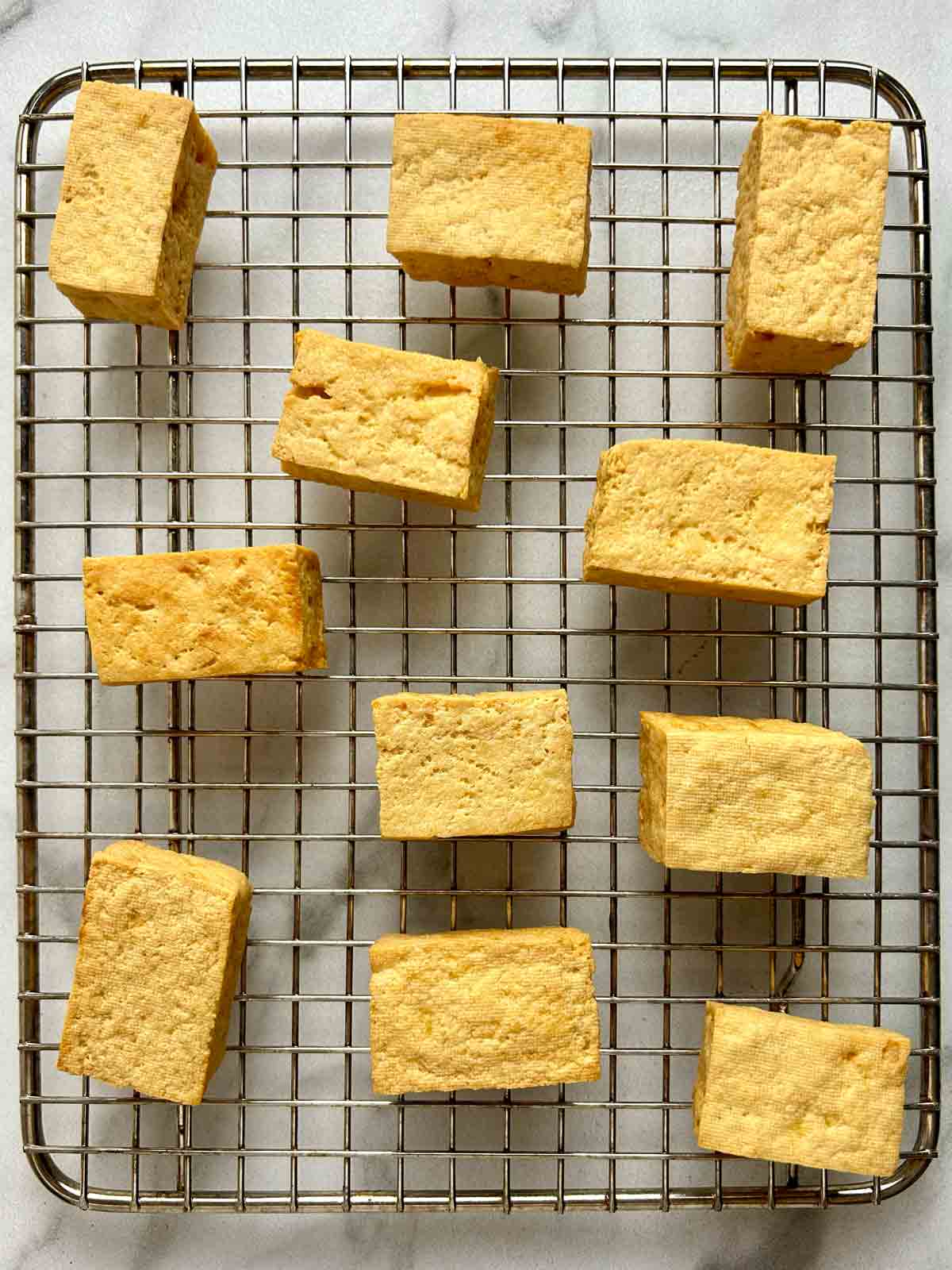 deep-fried tofu resting on wire rack.