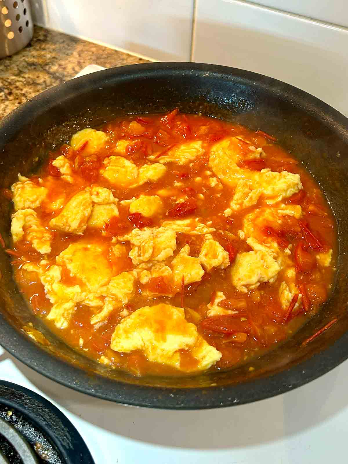 tomato sauce with scrambled eggs in pan.