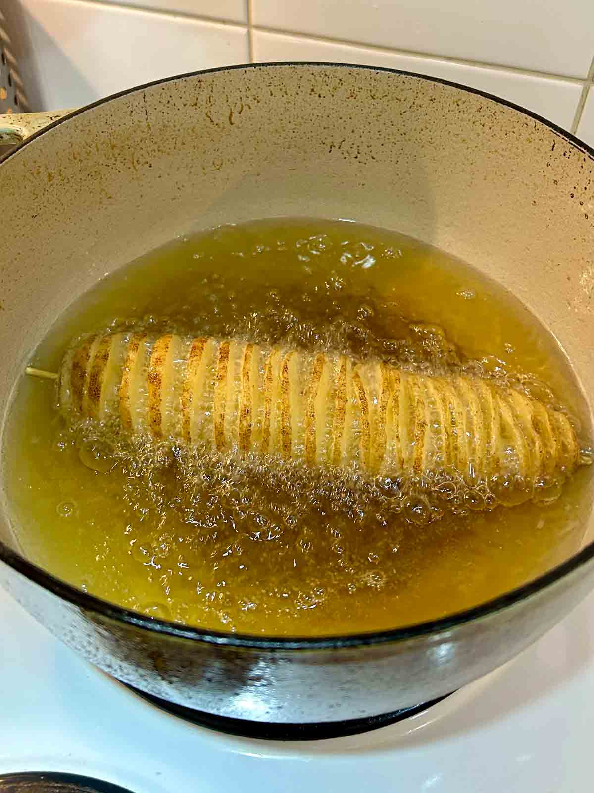 potato spiral being fried in oil.