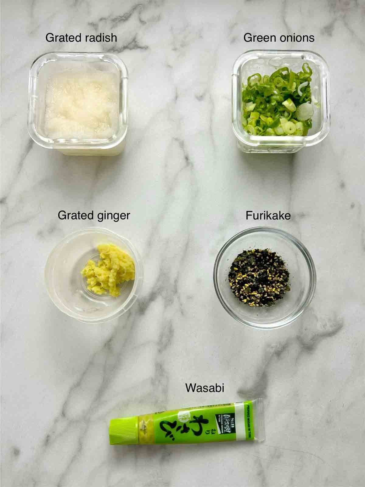 toppings prepped in bowls; grated radish, sliced green onions, grated ginger, furikake, and wasabi.