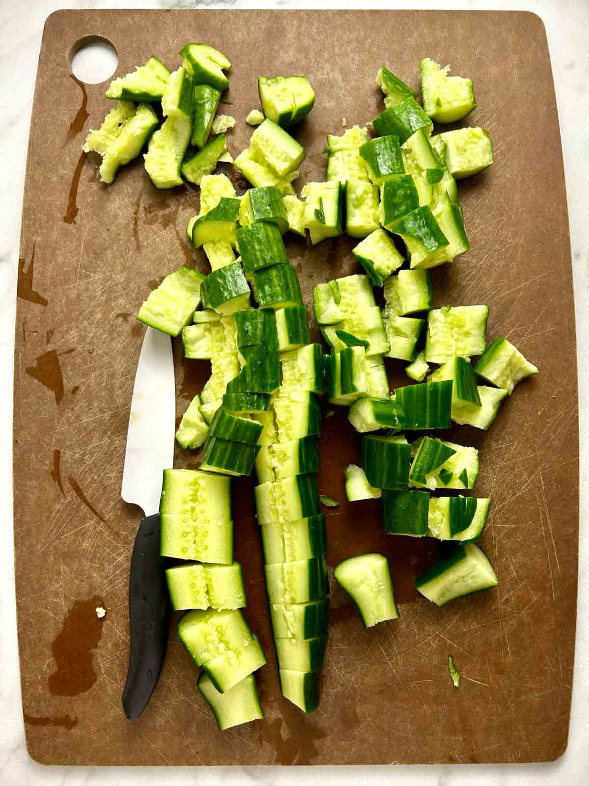 chopped cucumbers on cutting board.