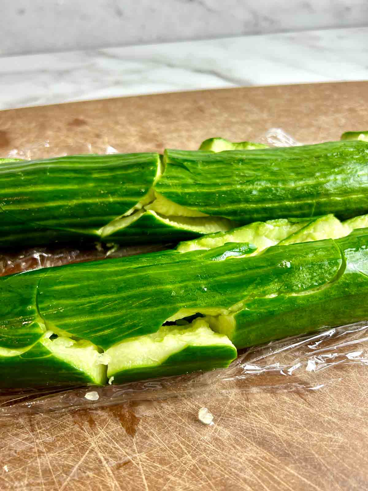 close up of smashed cucumber with sides split open.