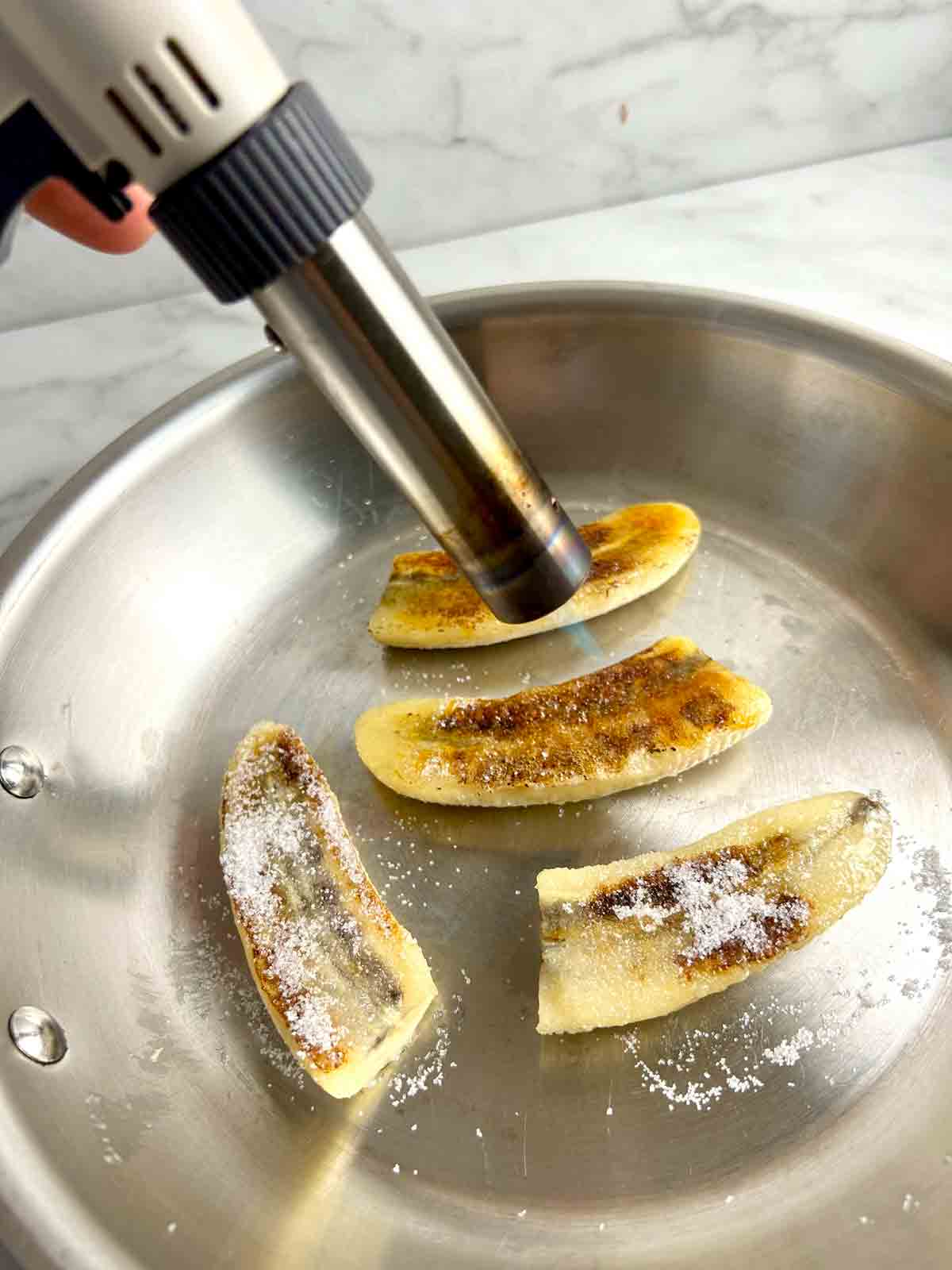 searing the sugar on top of banana with blowtorch.