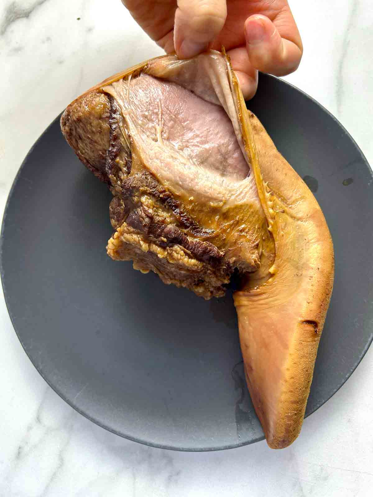 skin being peeled off of cooked beef tongue.