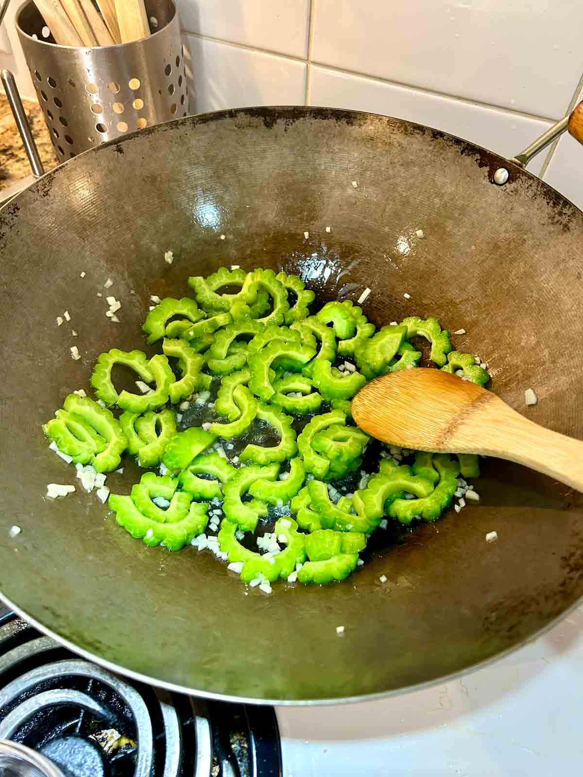 bittermelon being cooked in wok.