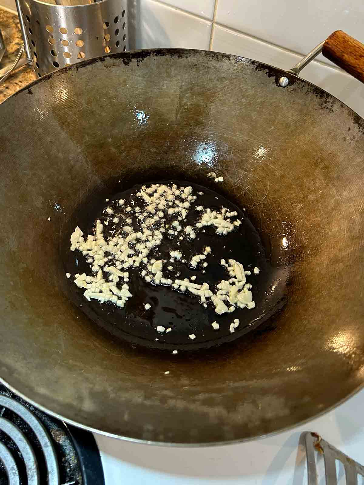 chopped garlic being cooked in wok.