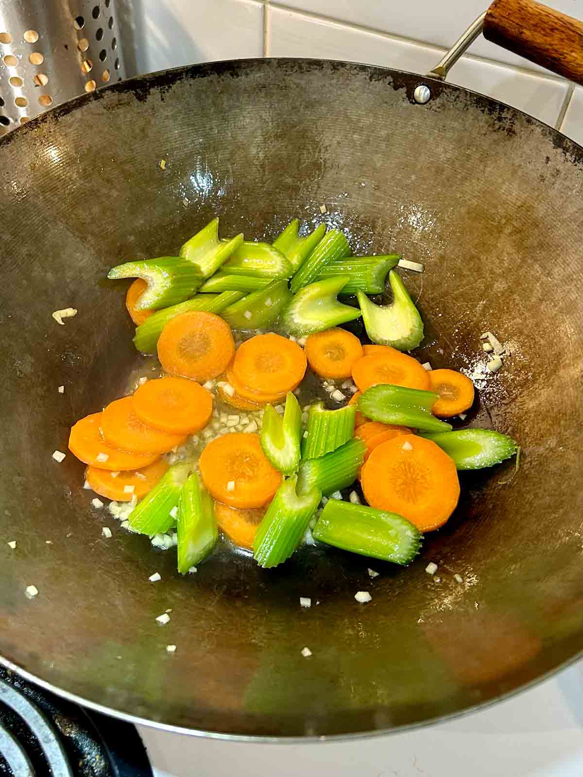 carrots and celery cooking in wok.