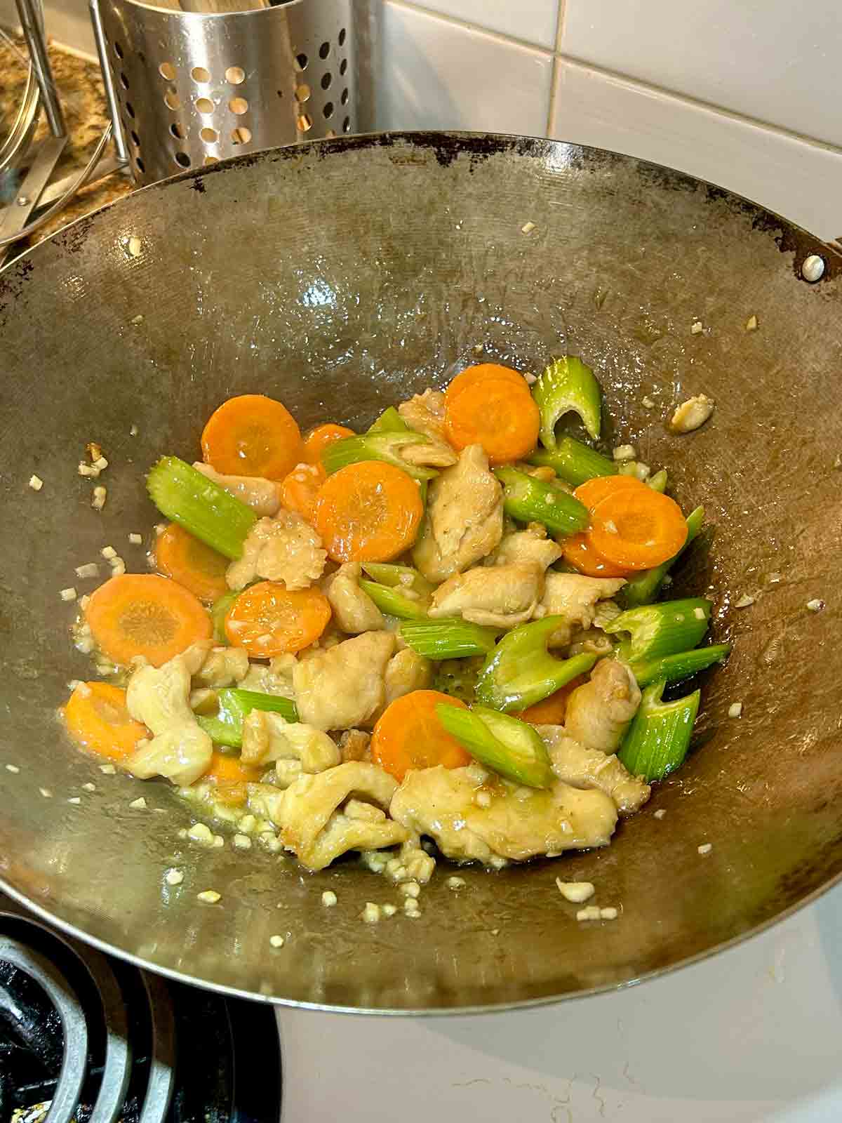 chicken and mixed vegetables cooking with sauce in wok.