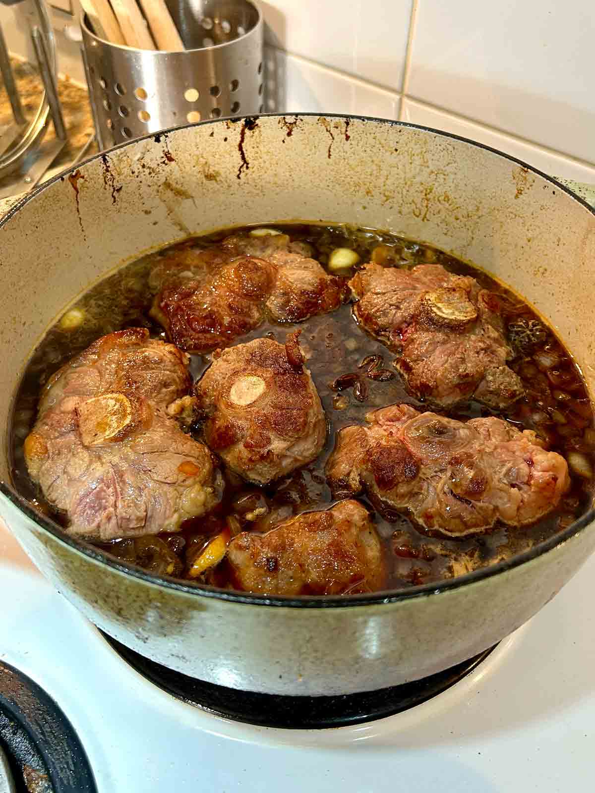 braising liquid ingredients added to pot of oxtail.