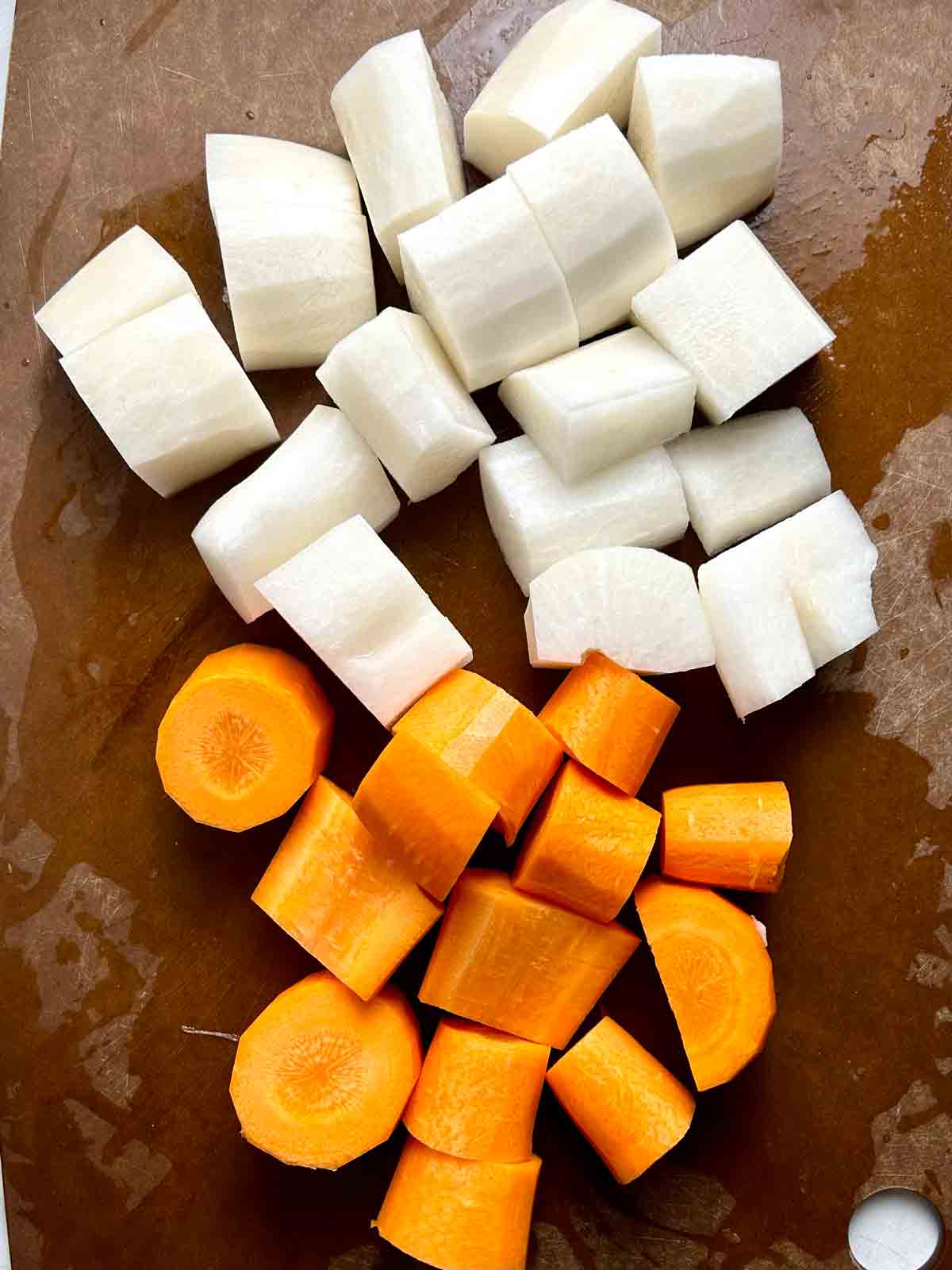 carrot and daikon chunks on cutting board.