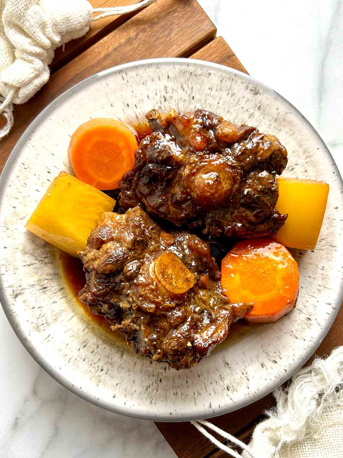 plate of braised oxtail with daikon and carrots.