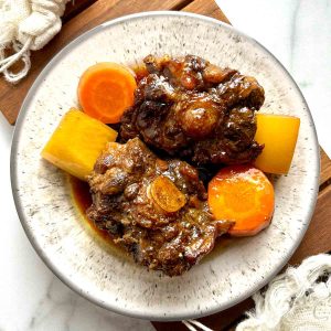 plate of braised oxtail with daikon and carrots.