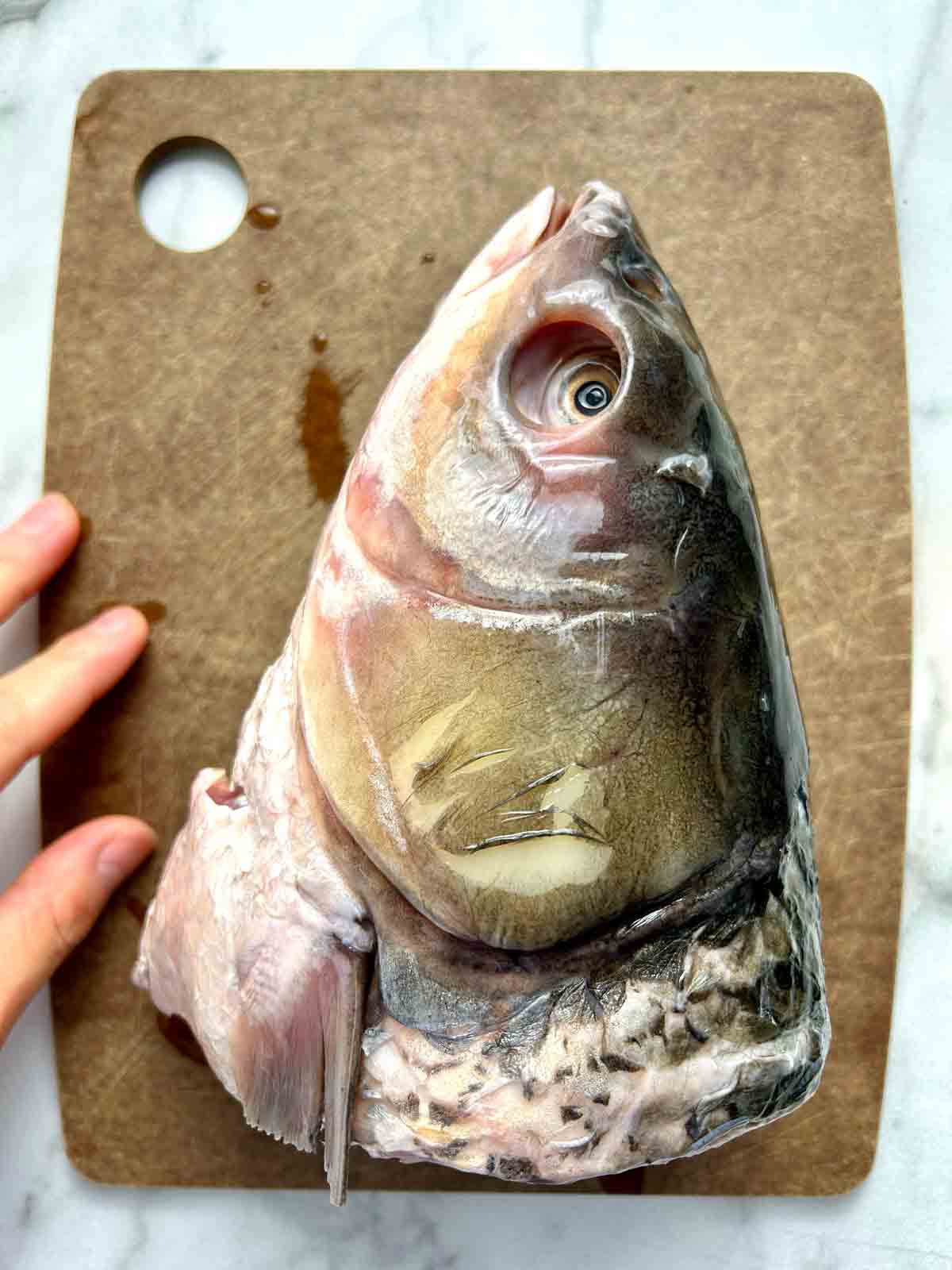 raw fish head on cutting board.