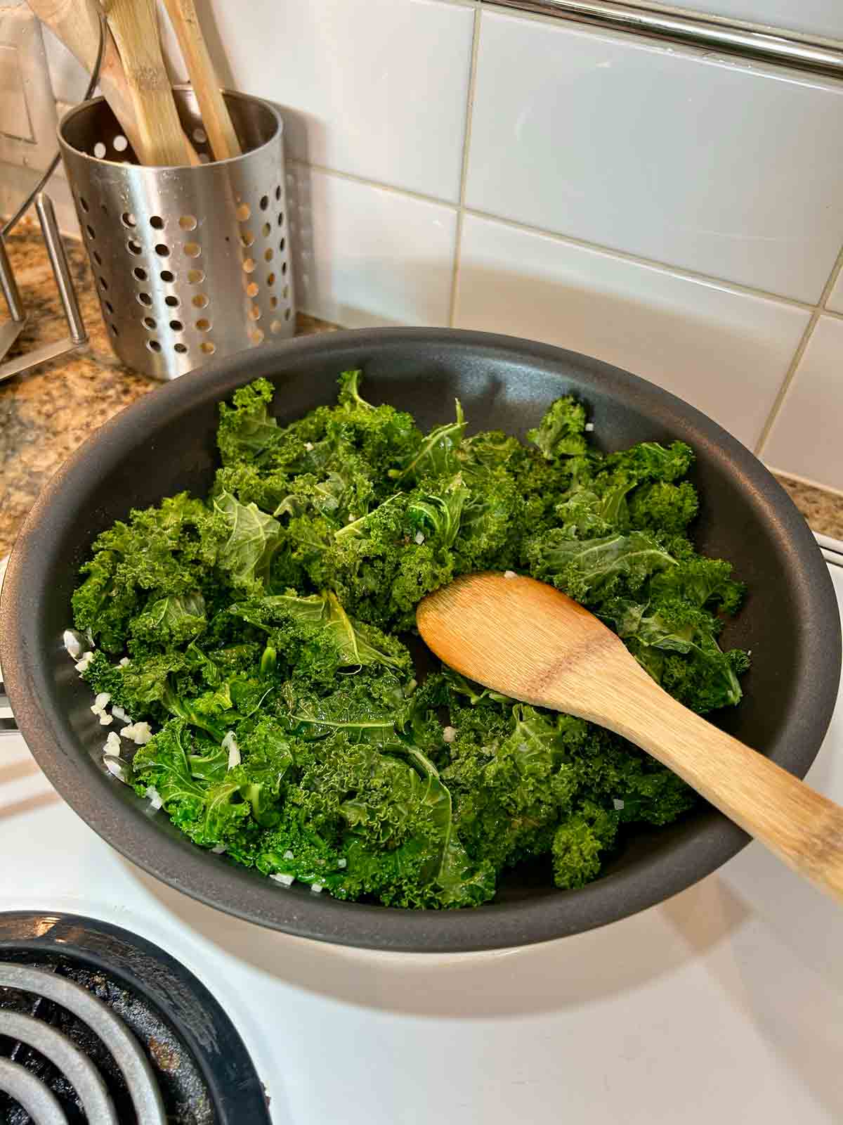 chopped kale being added to pan.