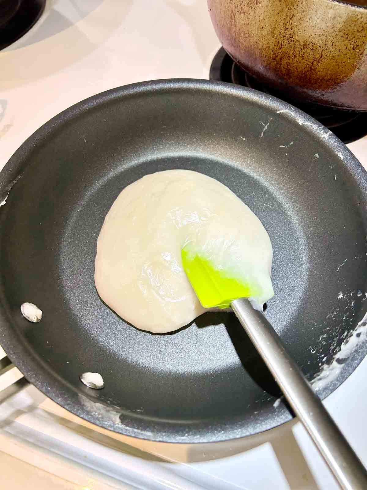 mochi dough being cooked in nonstick pan.