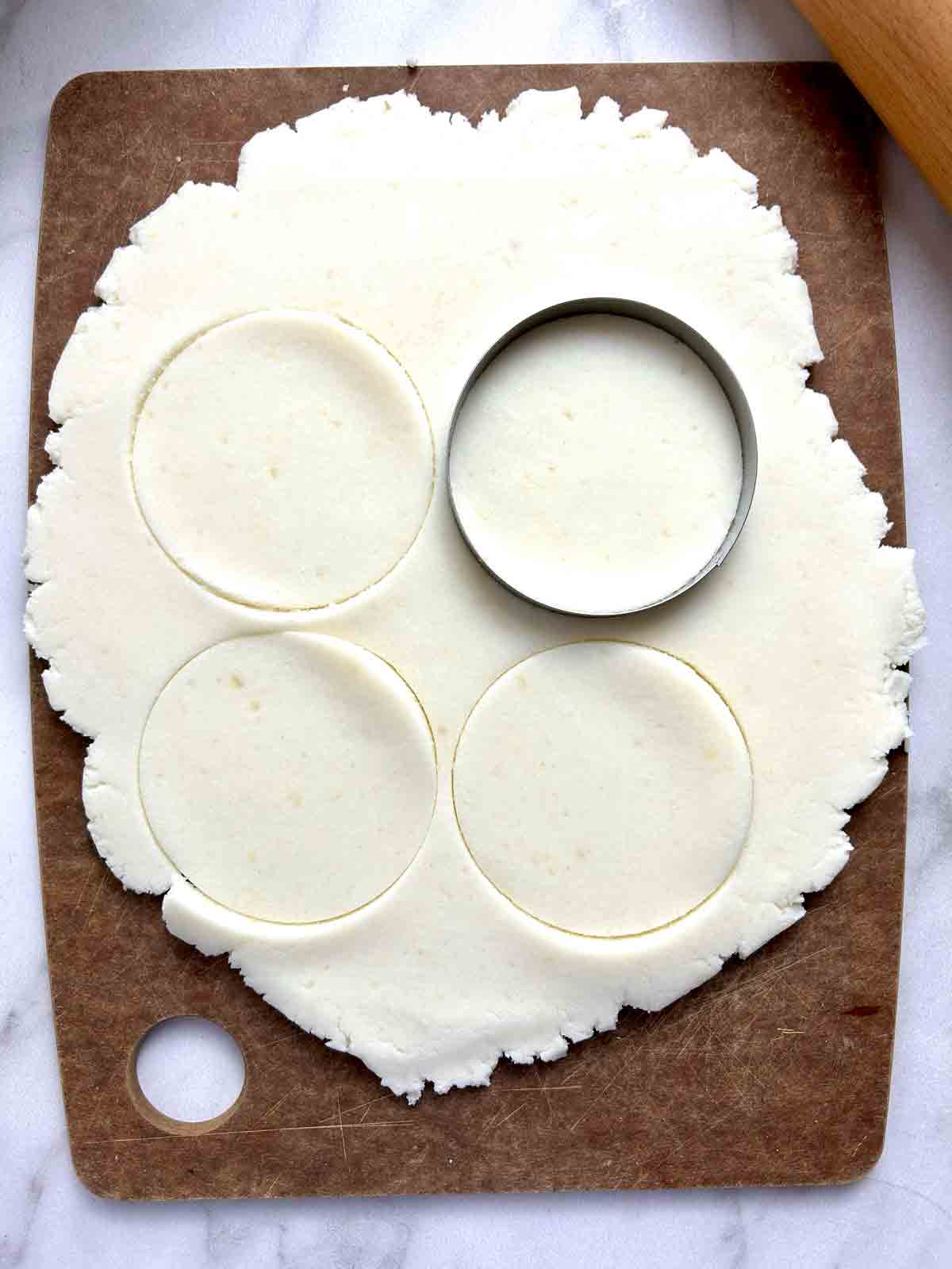 rolled out dough being cut with cookie cutter.