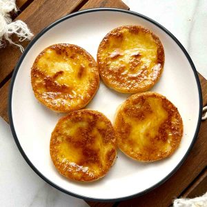 four potato mochi brushed with glaze on plate.