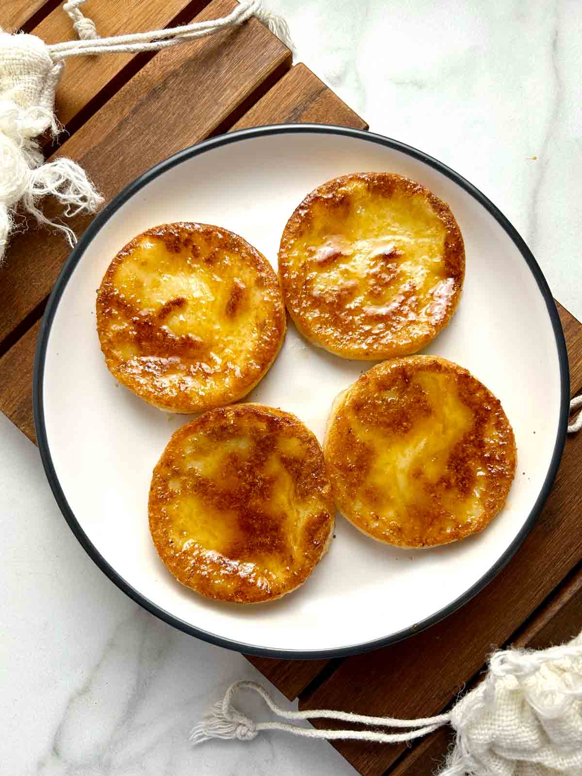 four potato mochi brushed with glaze on plate.