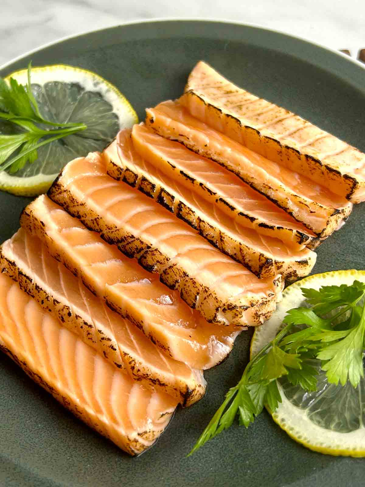 close up of salmon tataki slices which were sliced before torching.