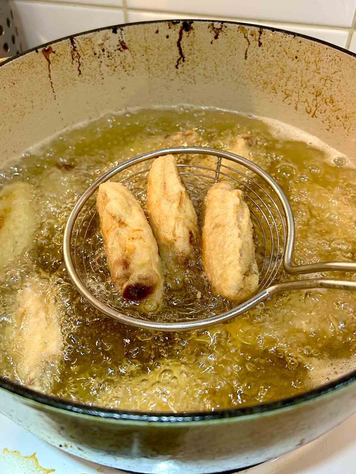 deep-fried wings being lifted out of hot oil.