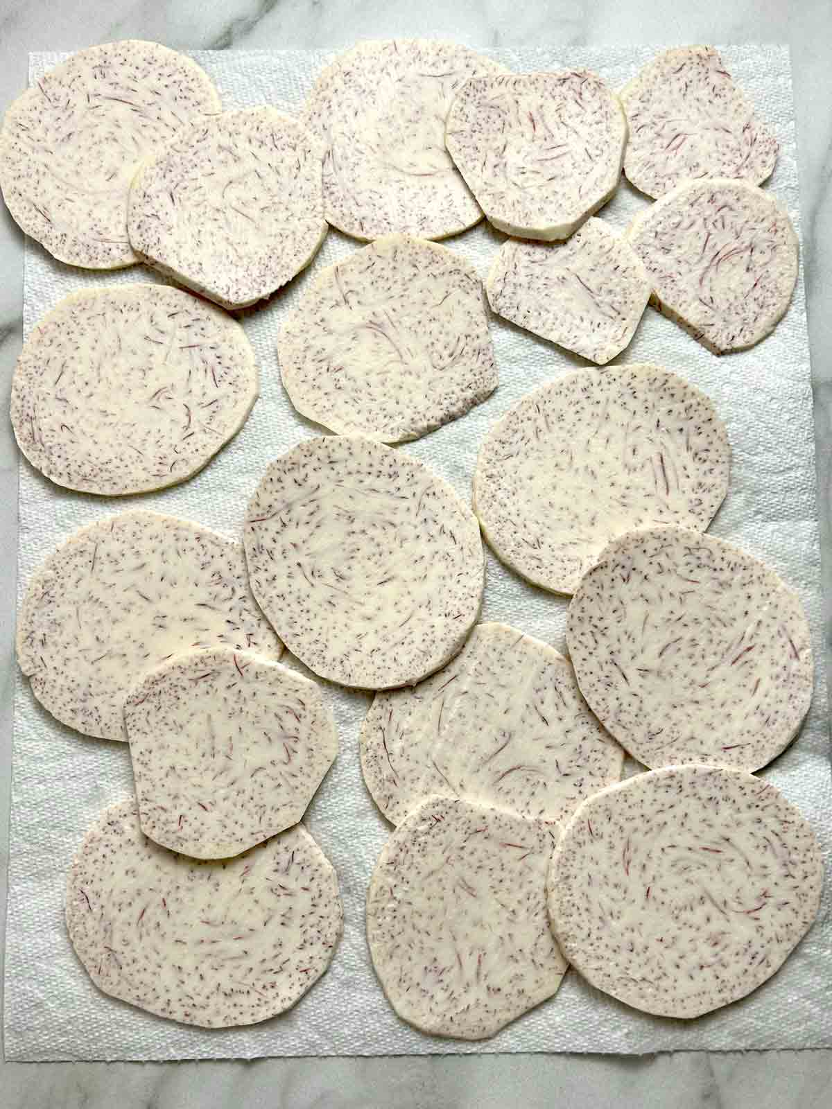 slices of taro being dried on paper towels.