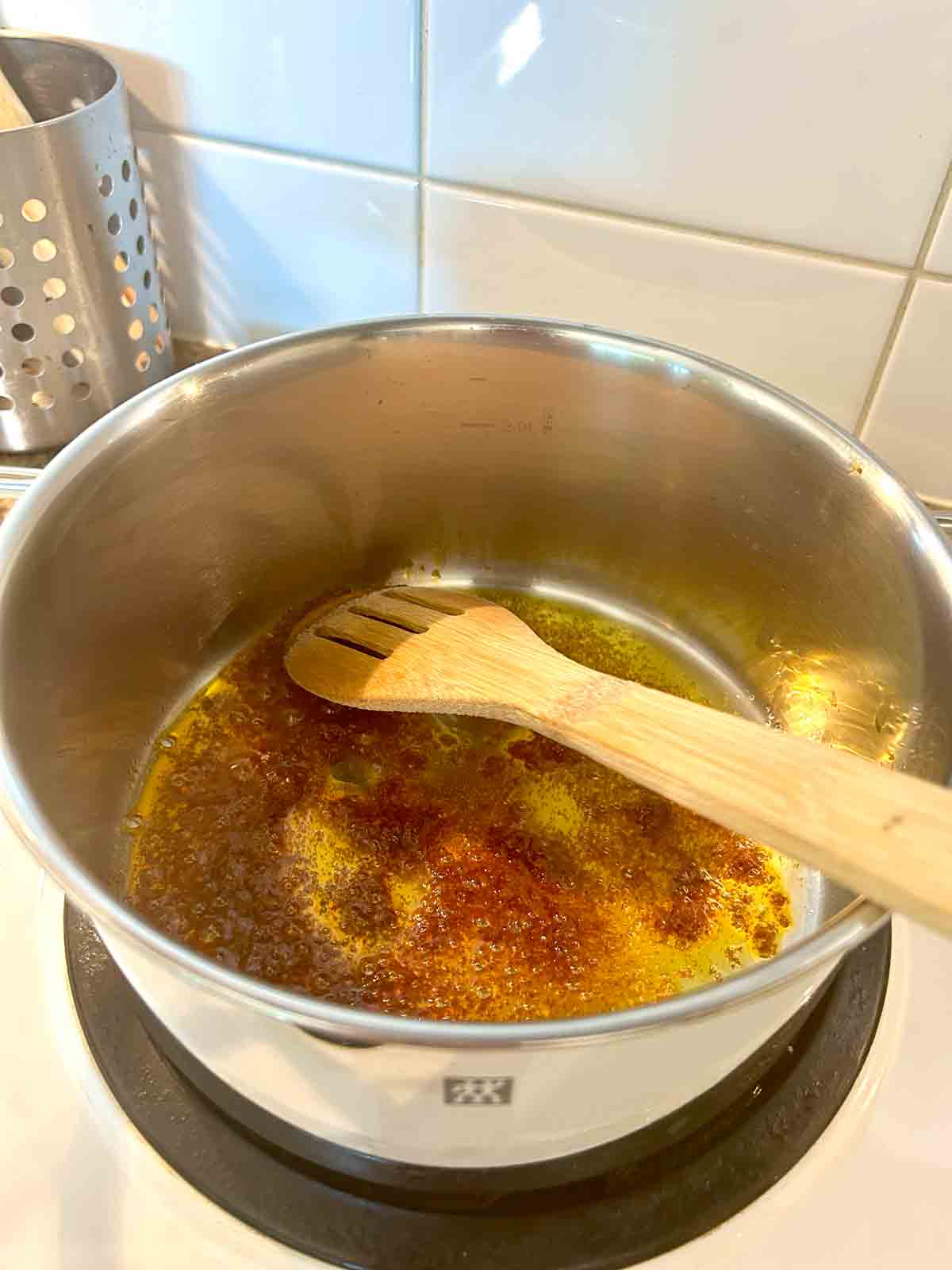 tom yum paste being sizzled in oil in pot.