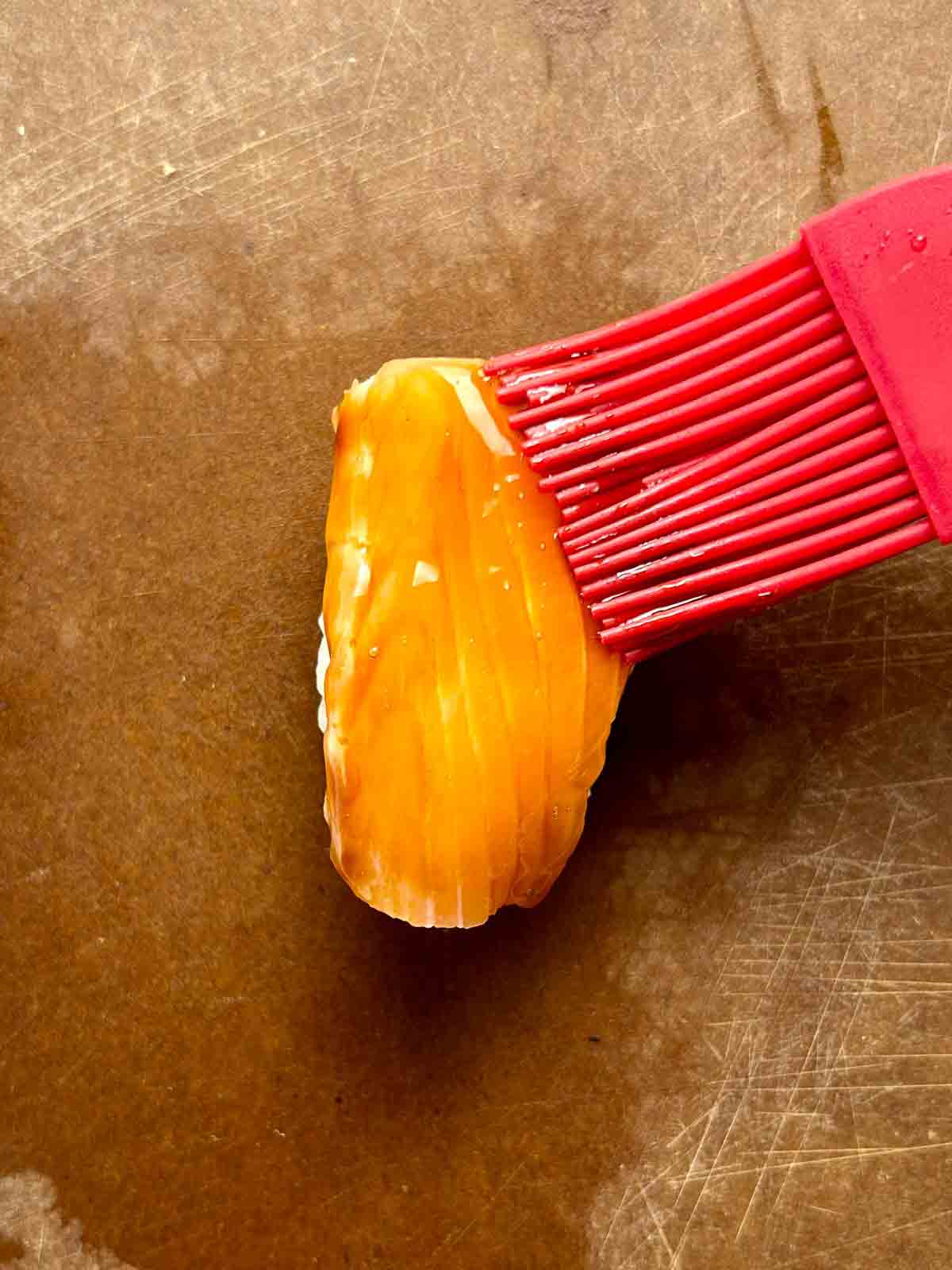 soy glaze being brushed onto salmon.