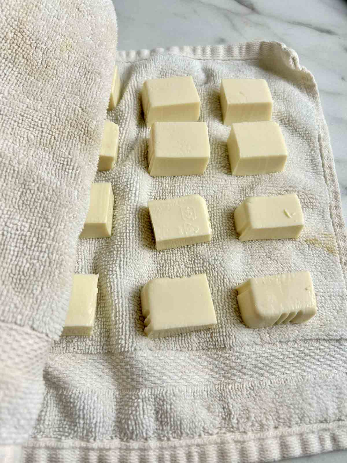 cubes of tofu drying on dish towels.