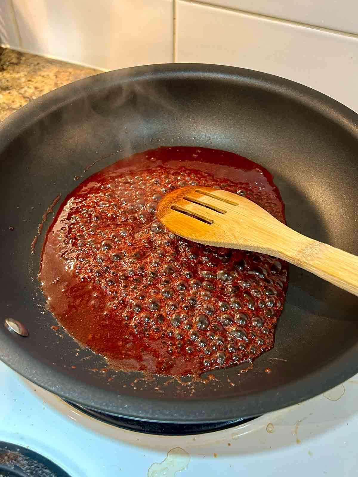 red glaze being reduced in pan.