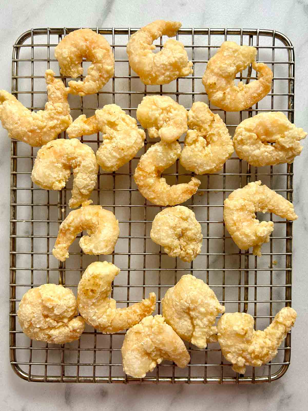 fried shrimp drying on wire rack.