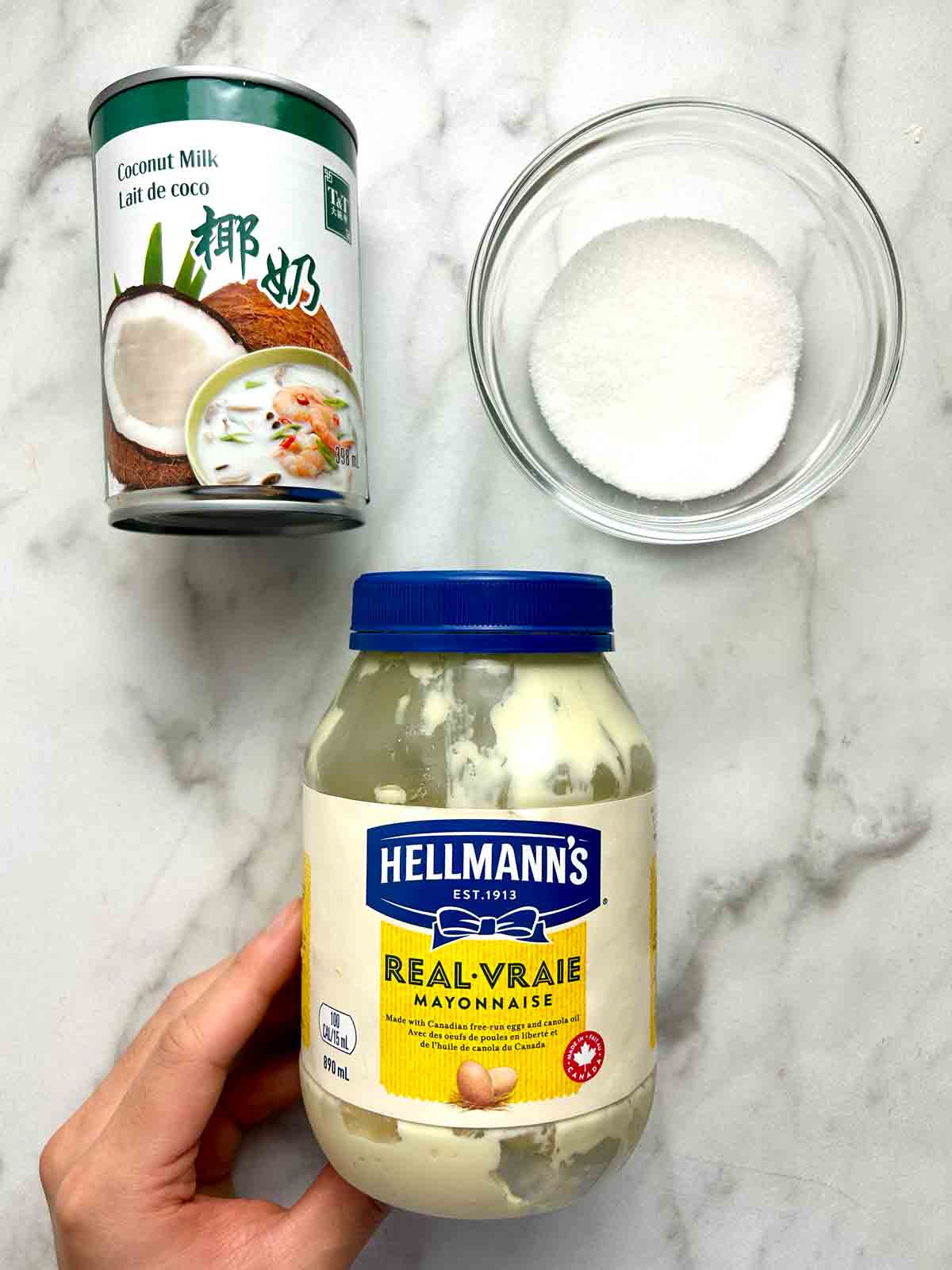 can of coconut milk, bowl of sugar, and jar of mayonnaise.