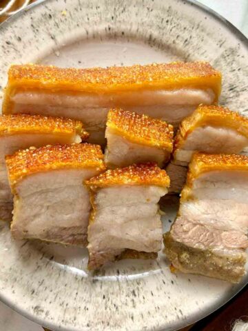 plate of crispy pork belly slices.