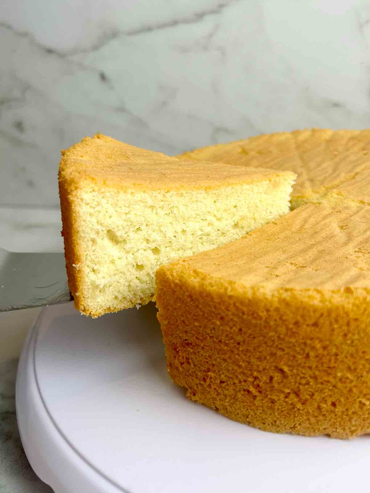 slice of sponge cake being lifted from cake.