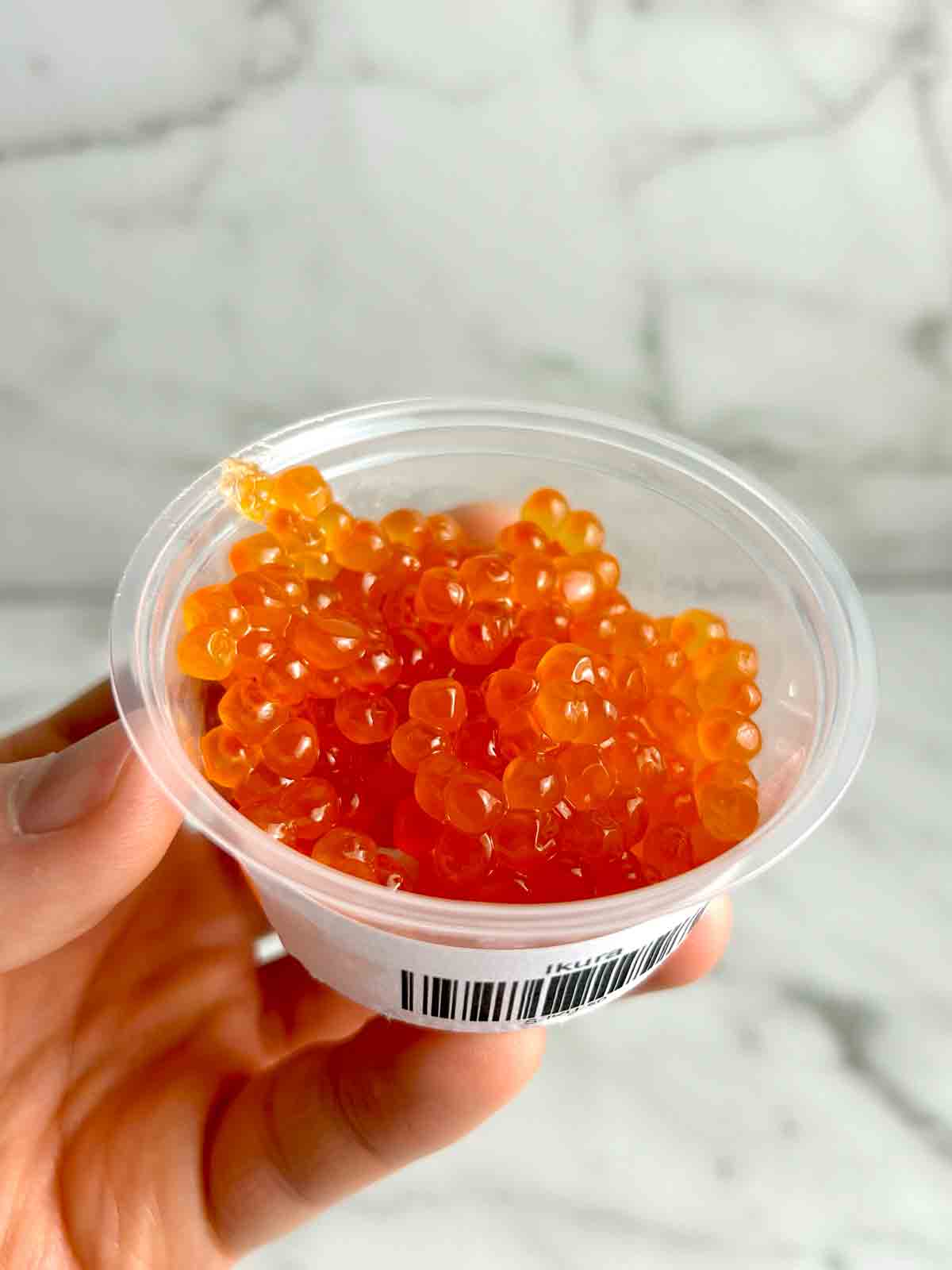 small container of ikura (salmon eggs)