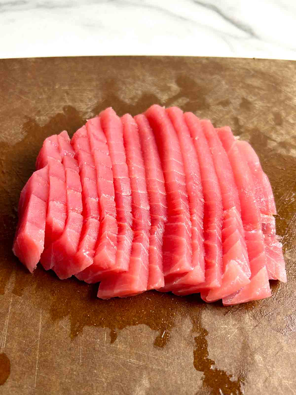 slices of Yellowfin tuna on cutting board.