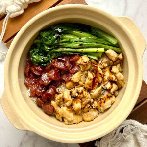 overhead shot of clay pot rice with chicken, Chinese sausages, and yu choy.