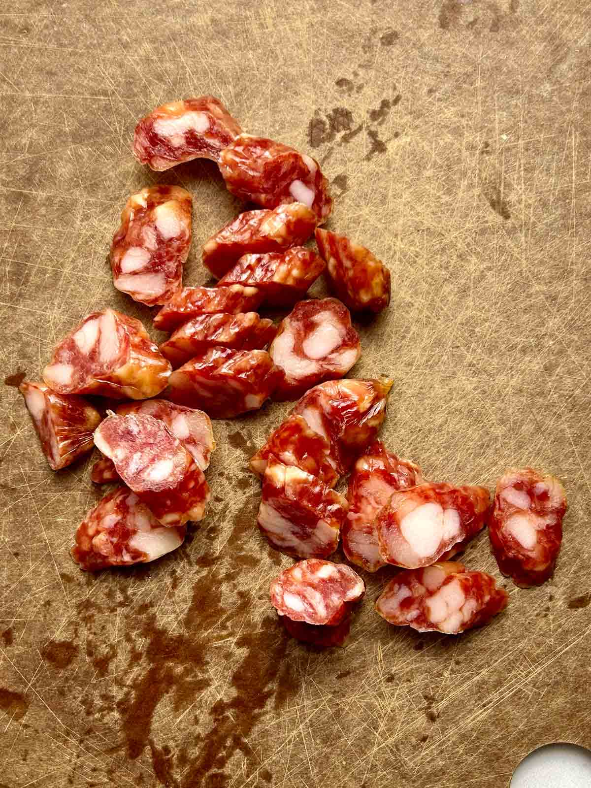 sliced Chinese sausages on cutting board.