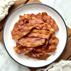 pile of crispy bacon strips on plate.