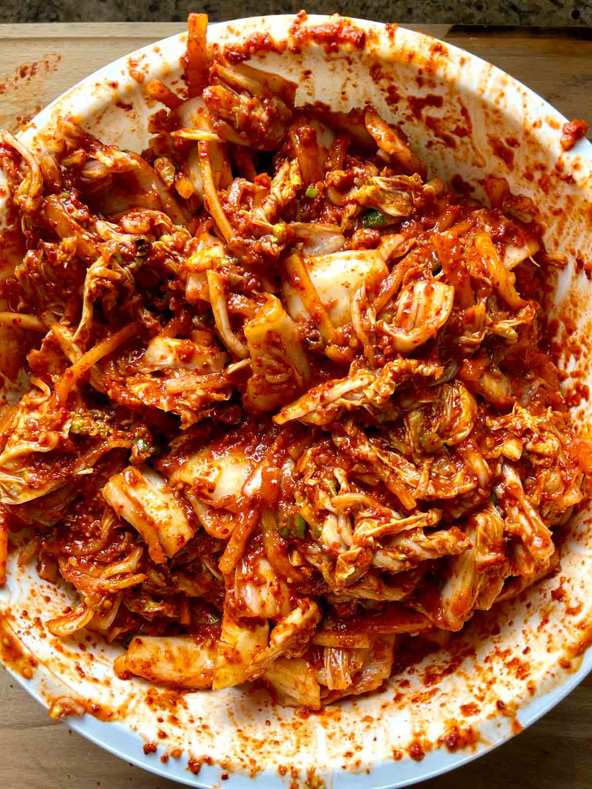 cabbage tossed with spice paste in large bowl.