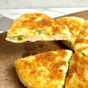 metal spatula lifting a piece of potato cheese bread.